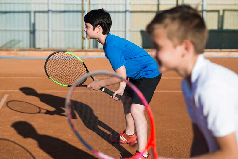 niños entrenando a tenis